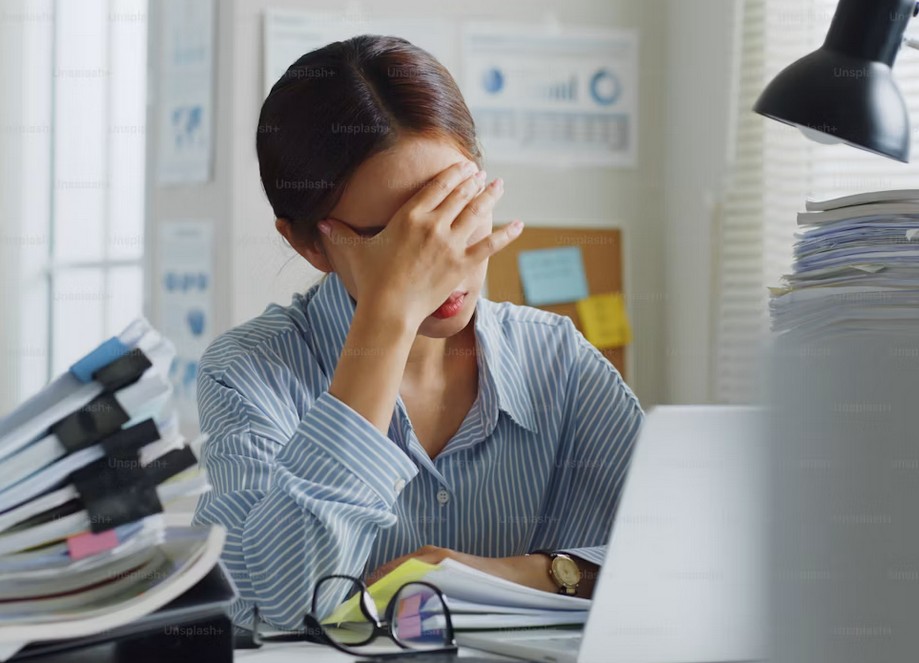 Femme qui se tient la tête en signe de fatigue 